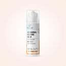 A single bottle of Radeq Lab Hexagonal Restore Balm centered on a soft peach-pink gradient background. The bottle is white with a clear cap and features black text with orange accents near the bottom.