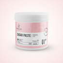A white plastic jar of Radeq Lab Sugar Paste, Premium Prebiotic Line, with a light pink label and white lid, set against a soft pink background.